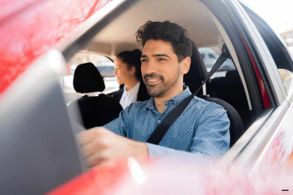 An uber driver driving a lady at the passenger's seat