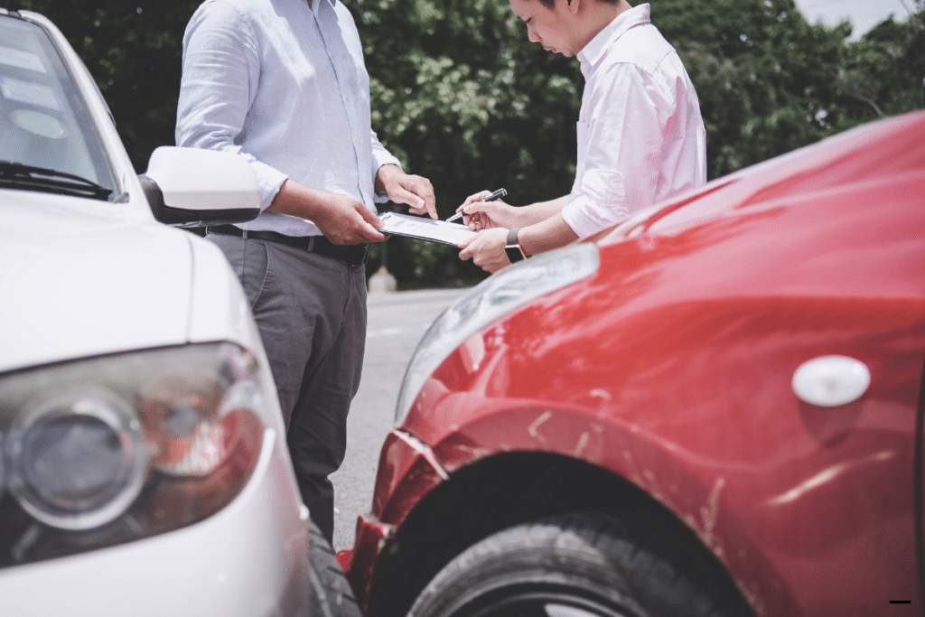 an man signing an insurance form at an accident scene