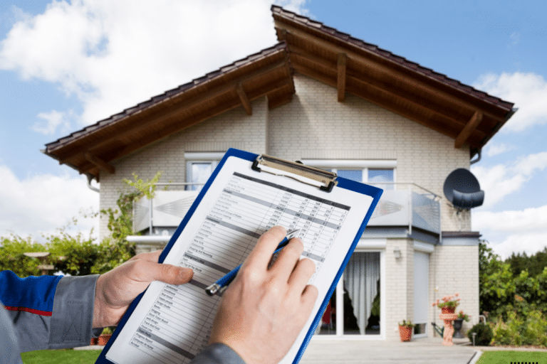 An insurance officer holding a document in front of a house