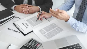 two attorneys sitting with insurance policy on the table